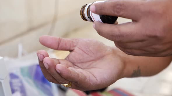 Covid-19 vaccine tablets view, Micro shot of dropping tablets over hand from a bottle alt