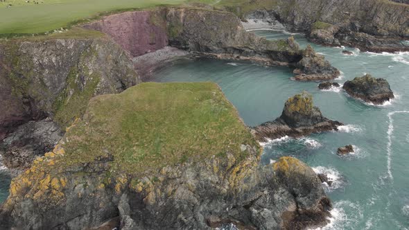 Drone shot of a unique looking rock formation on the Irish coast line. alt