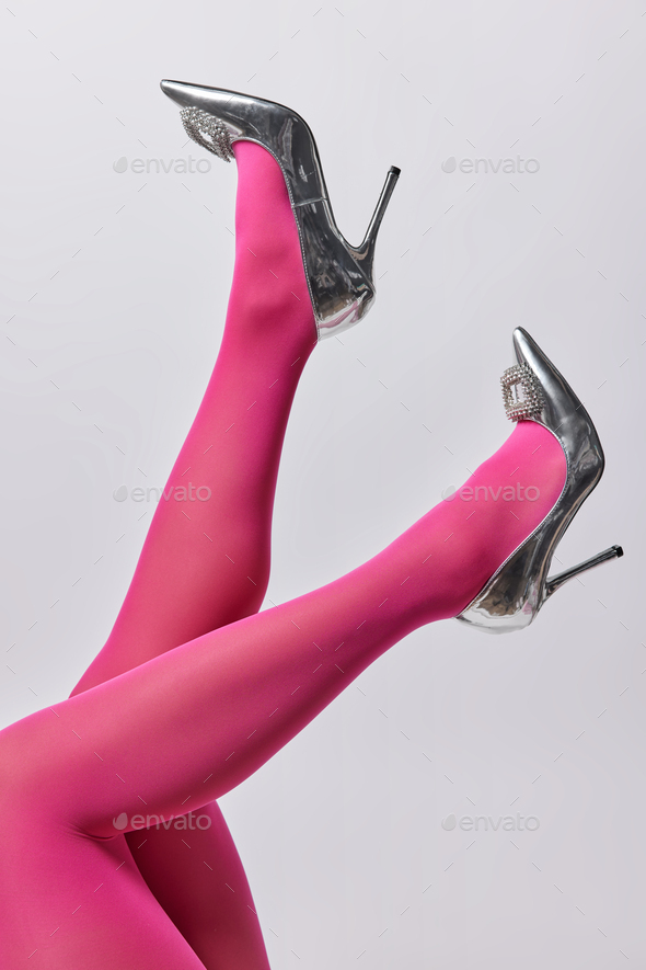 Uncecognizable woman in pink tights and high heeled silver shoes