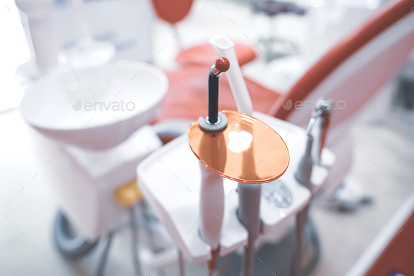 closeup of dental filling polymerization ultraviolet lamp near chair in dentist office - Stock Photo - Images