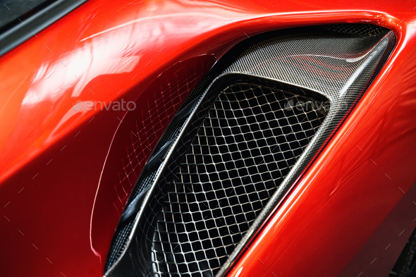 detail of sport car with red metal hood and black air flow intake ornament - Stock Photo - Images