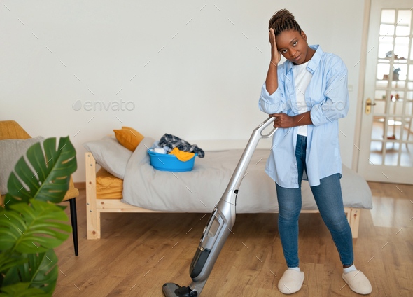 Exhausted black woman housewife cleaning house alone