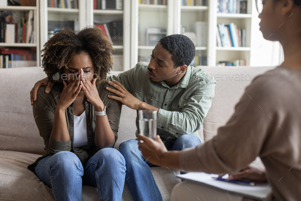 Broken black woman crying while having family therapy session