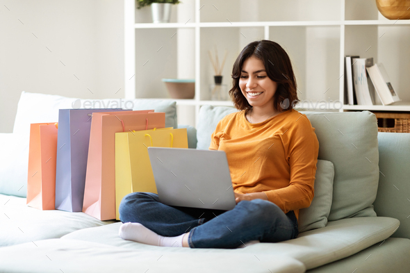 Smiling Young Arab Woman Shopping Online With Laptop At Home