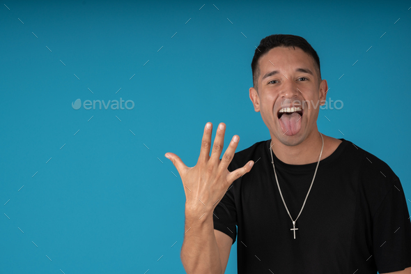 Man Fingering The Number Five And Sticking Out His Tongue Stock Photo