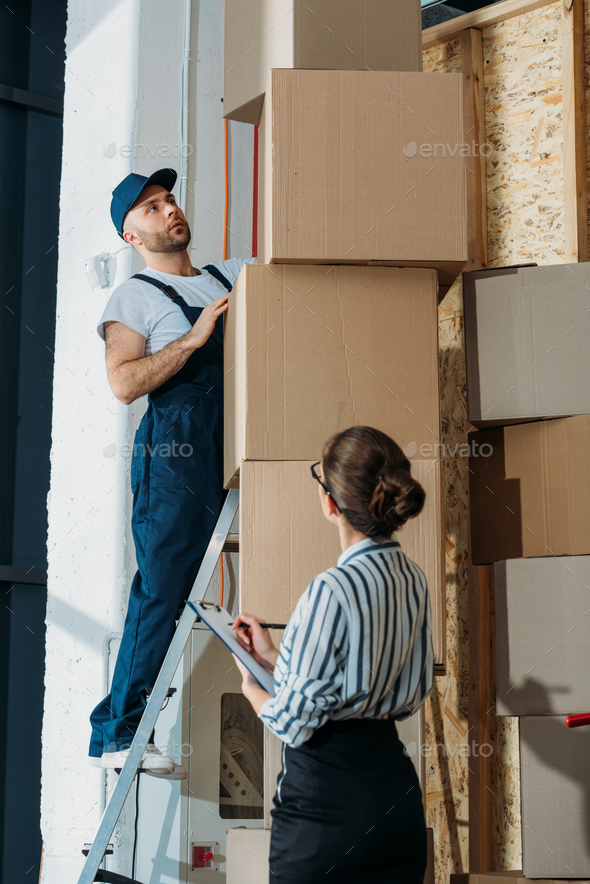 Businesswoman filling checklist while loader man standing on a ladder