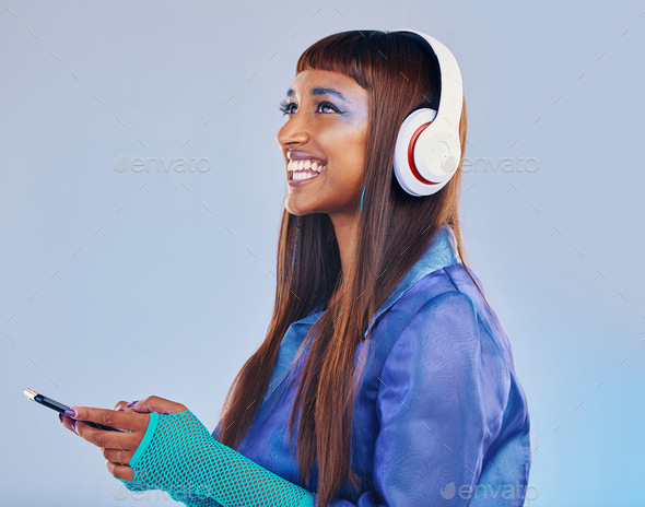 Headphones, black woman and phone isolated on blue background for cyberpunk fashion and gen z think