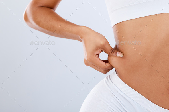Fat, lose weight and woman touching stomach in studio with liposuction mockup, space or background.