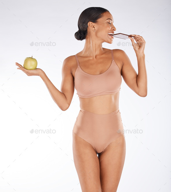 Apple, body and woman eating chocolate in a studio for a sweet snack, candy or craving. Health, wel