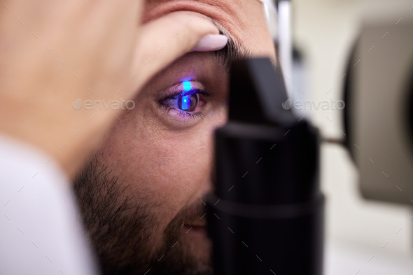 Eye exam, vision or laser test for a man with machine at optometry consultation for retina problem. - Stock Photo - Images