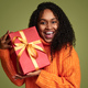 Smiling ethnic woman with present in studio - PhotoDune Item for Sale