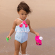 Little toddler girl standing on sandy beach and looking at wave in the summer - PhotoDune Item for Sale