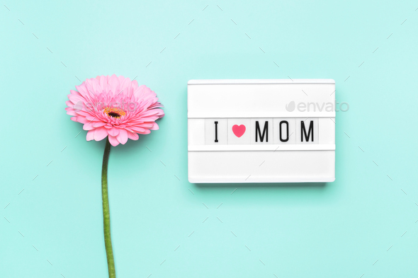 Mother\'s day concept. I love mom text and pink gerbera flower on turquoise background