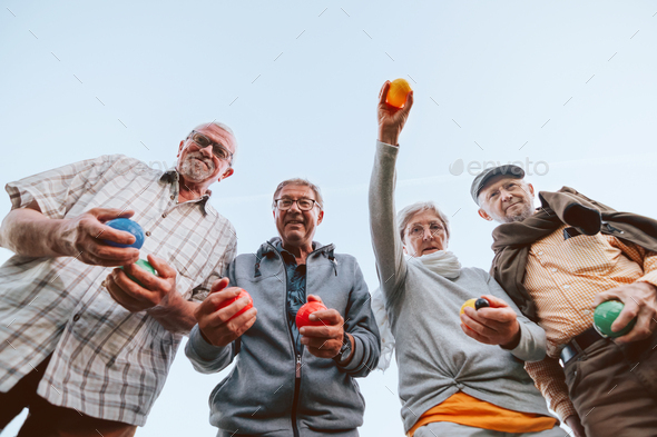 Elderly Friends Enjoying Outdoors Playing game of bawls