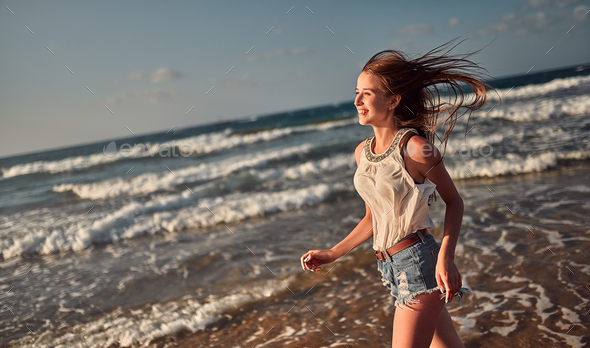 Female Running On Beach Over Beautiful Sky Stock Photo, Picture
