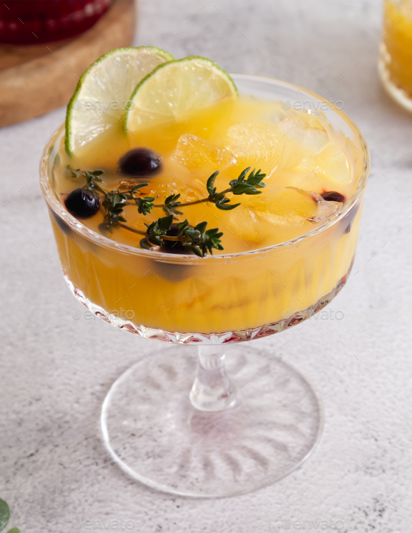 Fresh cocktail with ice, orange juice and grenadine syrup decorated with berries close-up