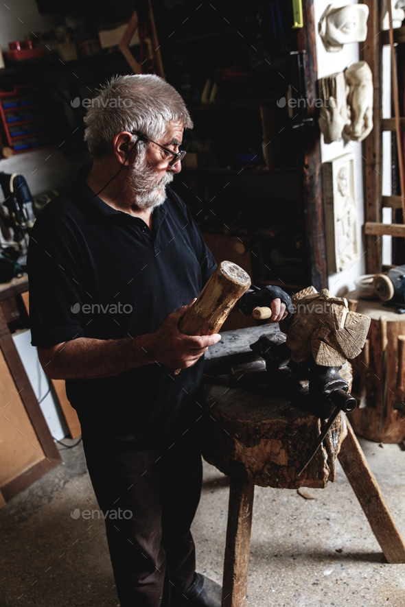 Senior sculptor working on his sculpture in his Stock Photo by zoranzeremski