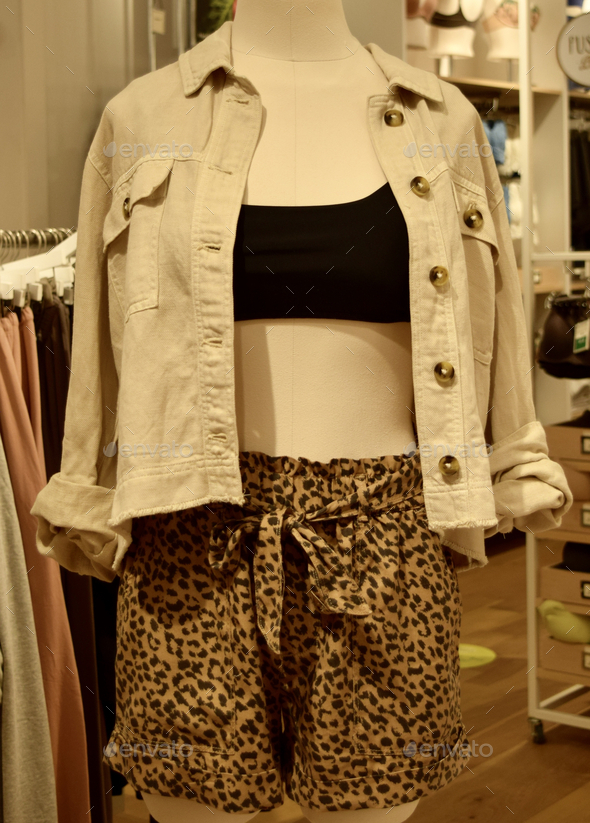 Pair of leopard-printed shorts paired with a black crop-top and white jacket on a mannequin