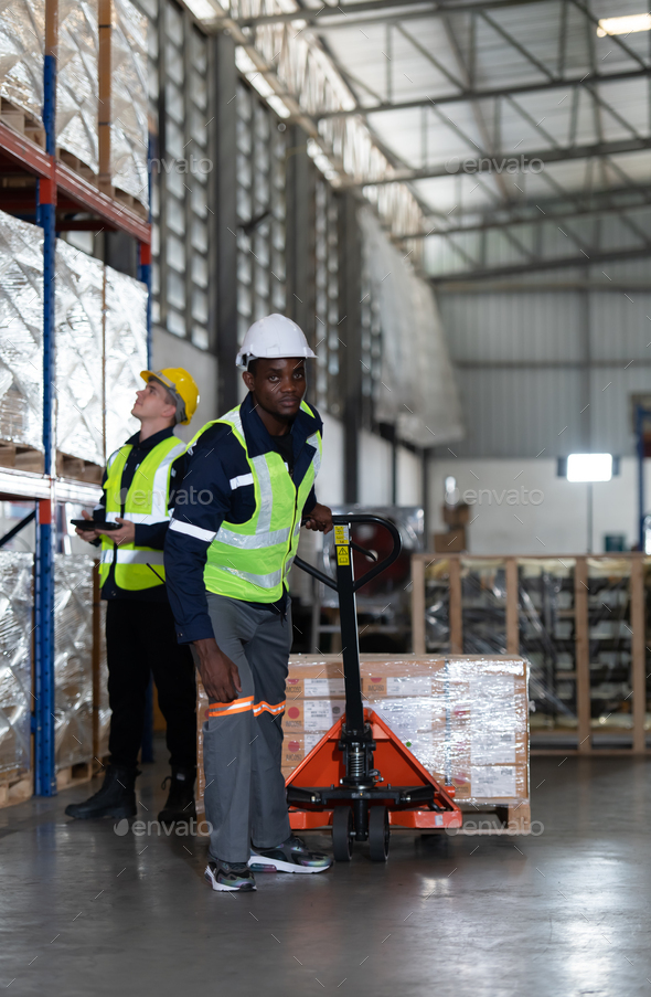 Worker in auto parts warehouse use a handcart to work to bring the box