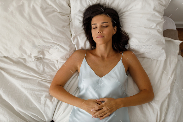 Healthy young woman dressing nightie lying on bed in bedroom Stock ...