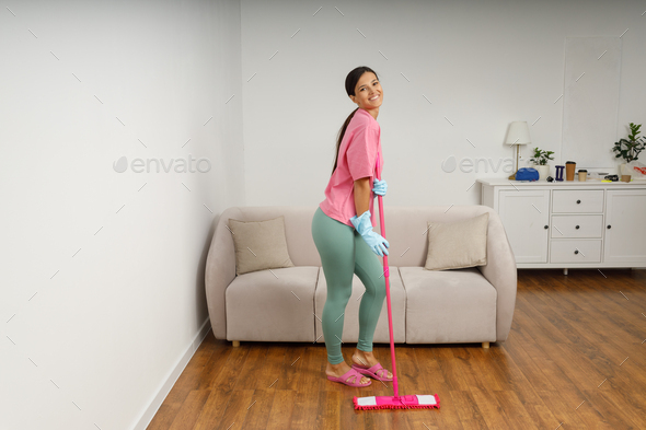 A young woman is cleaning mop living room.