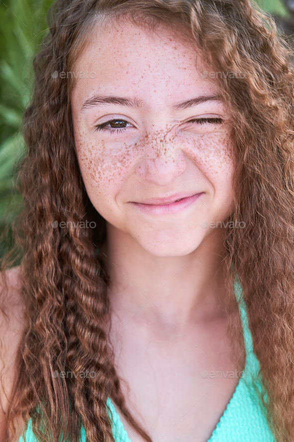 Cheerful freckled girl looking away, smiling, laughing. Close up of ...