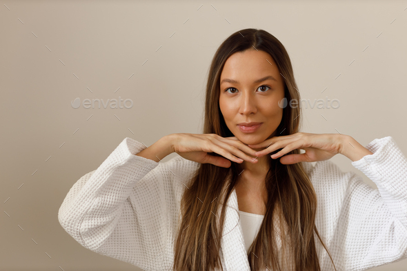 Young multiracial woman doing face building yoga and facial gymnastics self massage