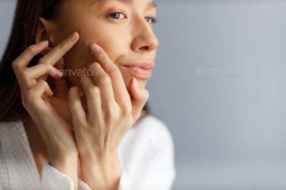 examines pimples on her face close up. Problematic skin on the face, acne. girl removing pimples  - Stock Photo - Images