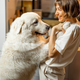 Woman plays with her dog on kitchen at home - PhotoDune Item for Sale