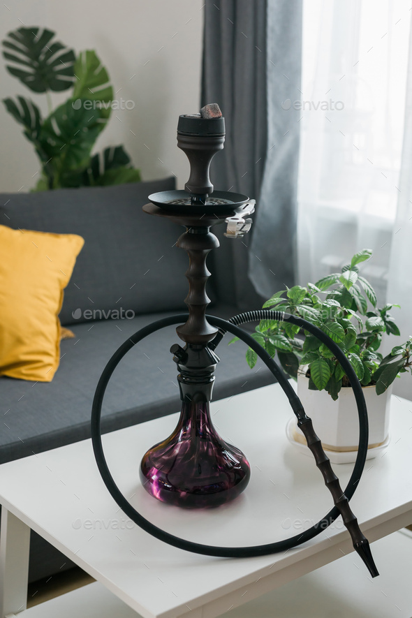 Shisha hookah bowl with red hot coals and craft tobacco. Modern hookah with coconut charcoal for