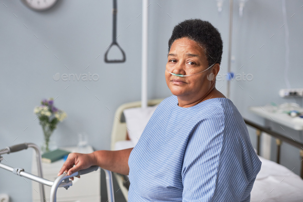 Senior woman looking at camera in hospital room with oxygen support
