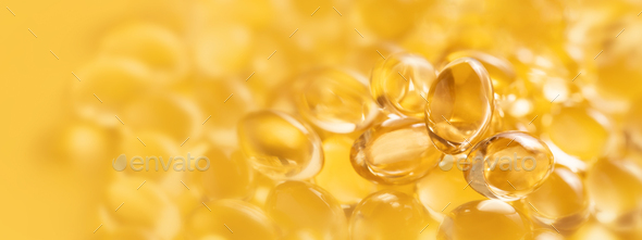 Banner closeup of oil gel capsules on yellow background. - Stock Photo - Images