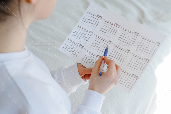 Woman planning her monthly menstruation calendar, mark the days of menstruation and ovulation. - Stock Photo - Images