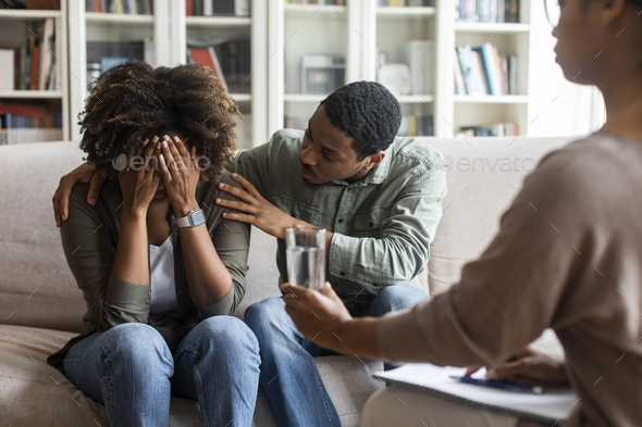 Loving Black Husband Comforting Crying Wife While Having Family Therapy 