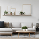Bright beige sofa, coffee table and empty frames on white wall. Cushions and plants. Concept art. - PhotoDune Item for Sale
