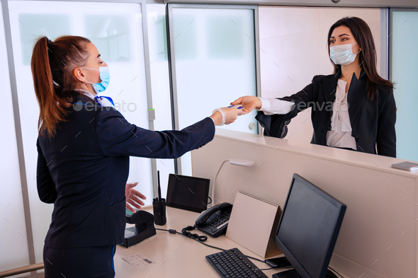 Passenger giving his documents for check-in to airport manager by counter - Stock Photo - Images