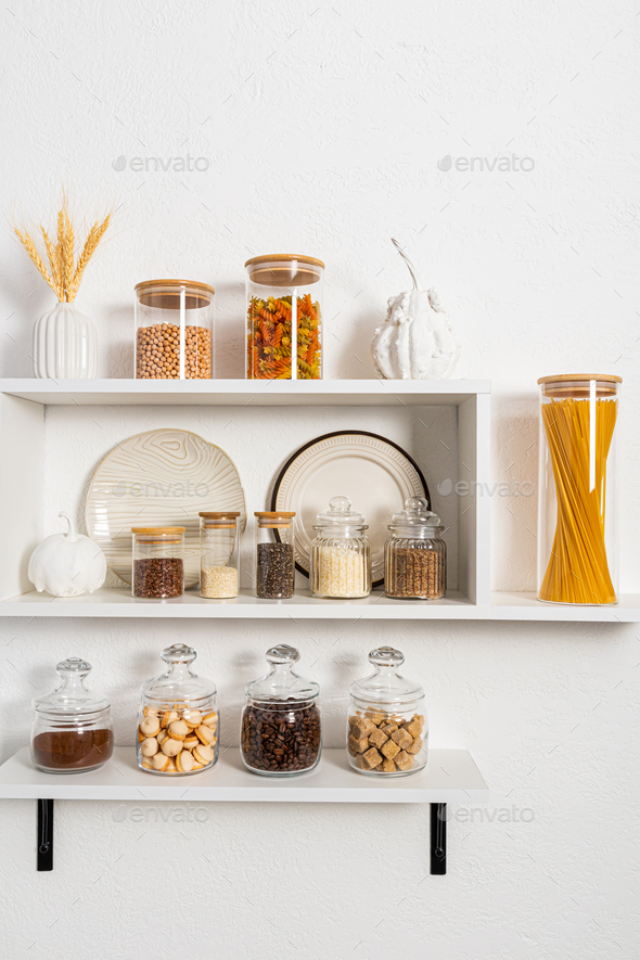 many different glass filled eco-banks for storing bulk products stand on open kitchen shelves