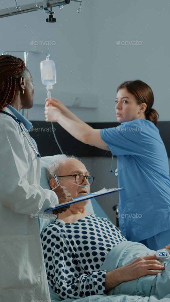 Nurse and african american doctor treat sick patient