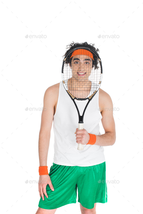 Young skinny sportsman looking through tennis racket isolated on white