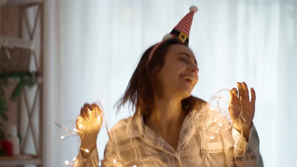 Slow Motion Portrait of Happy Cheerful Pretty Woman Wearing Pajama and Little Elf Cap Headband alt