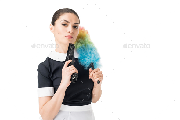 Professional maid in uniform holding duster and gun isolated on white