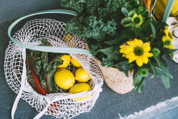 Sustainable zero waste shopping concept. Mesh bag with lemons and greens