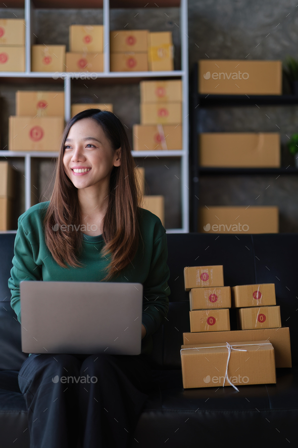 Portrait of Asian young woman SME working with a box at home. small business owner entrepreneur SME - Stock Photo - Images