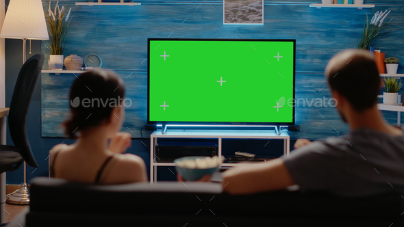 Caucasian people enjoying green screen layout on tv