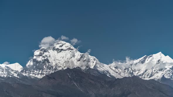 Snow Peak of Dhaulagiri Mountain at Sunrise Among Moving Clouds in the Himalayas in Nepal. Timelapse alt
