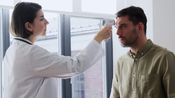 Doctor Measuring Patient's Temperature at Hospital alt