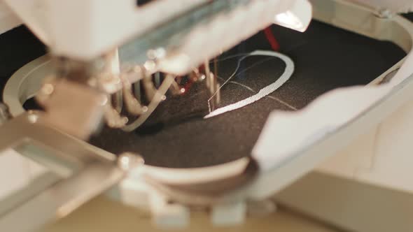 The automatic embroidery machine is working at high speed. Close-up alt