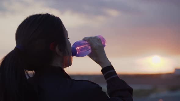 Young Athletic Woman Resting After Outdoors Workout and Drinking Water alt