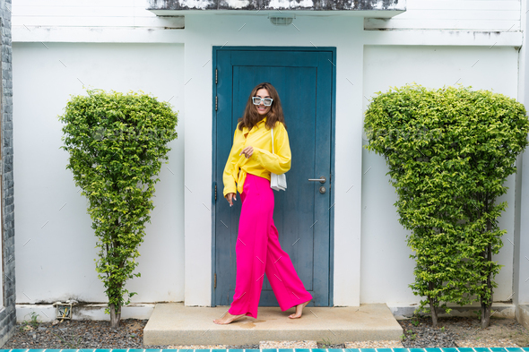 Stylish fit fashion women in bright pink wide leg pants and yellow