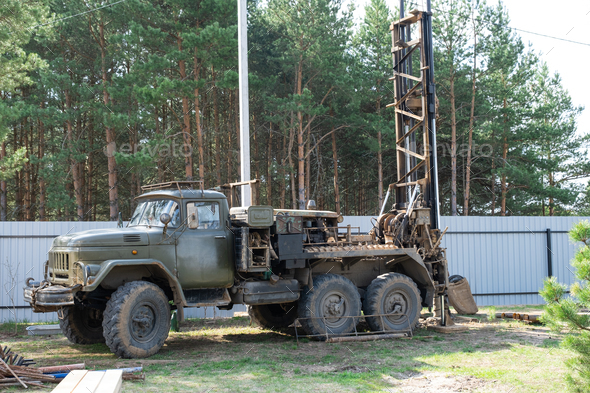 Drilling rig on zil car are drilling artesian well for water in ground.